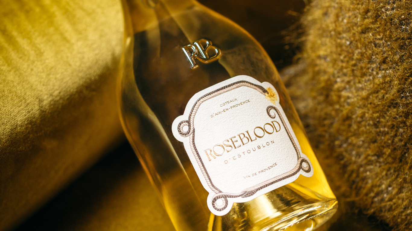 Bouteille de Roseblood Blanc sur un canapé en velour jaune